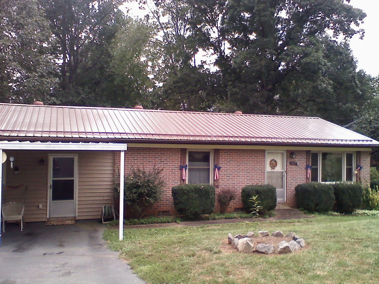 Bronze metal roof and carport on a brick ranch home — Roof Repair work by our crew in Coleman