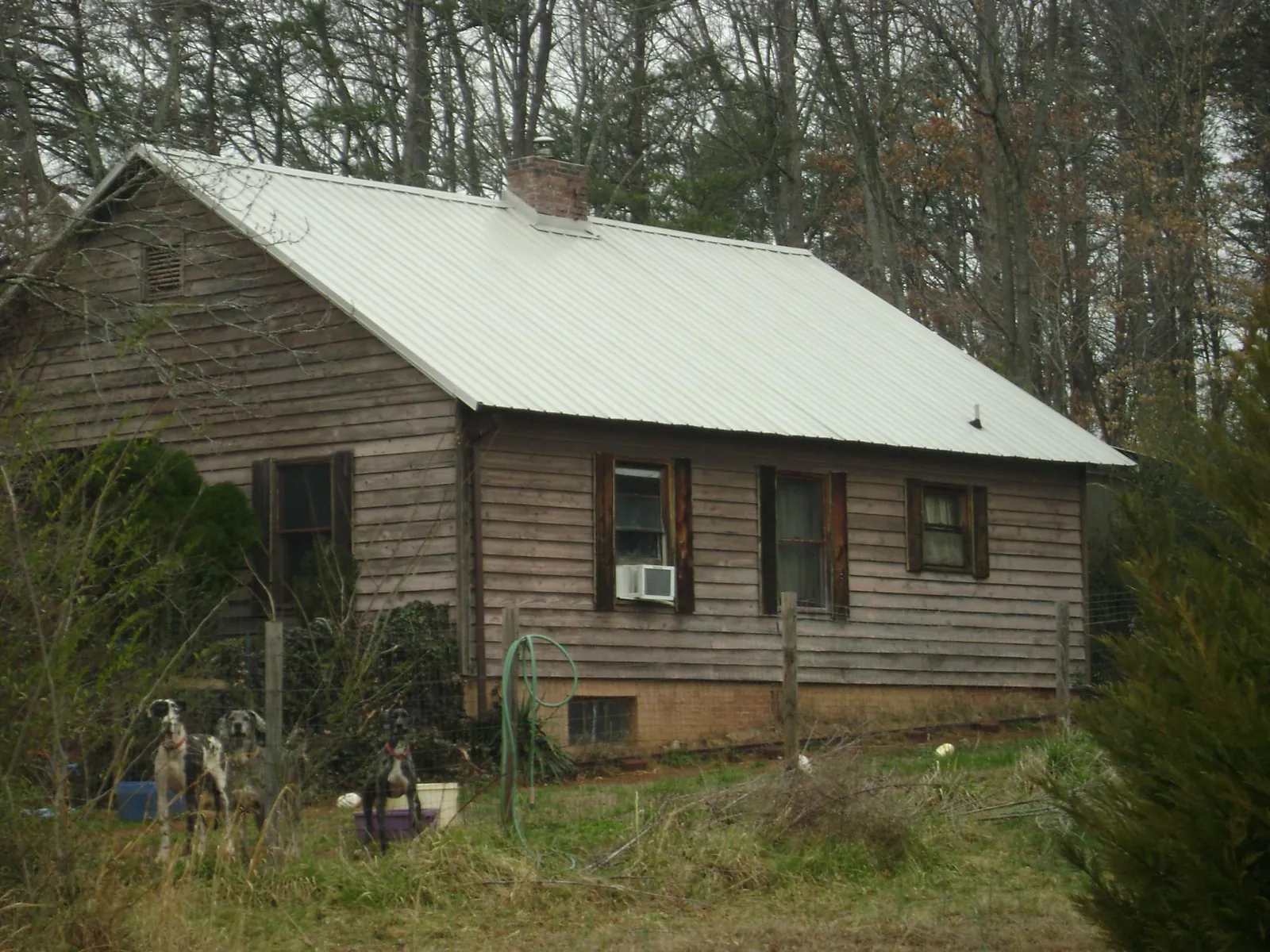 White metal roof on an old wood sided farmhouse, from a Metal Roof Installation job in Coleman